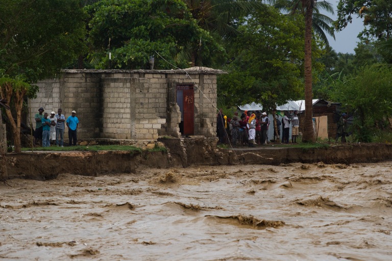 Residents stand on the banks of a river that swept away five homes in Port au Prince. Hurricane Sandy passed to the west of Haiti October 25, 2012 causing heay rains and winds, flooding homes and overflowing rivers. Photo Logan Abassi UN/MINUSTAH